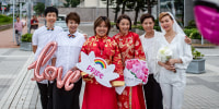 Three couples stand together outside